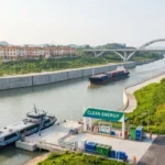 เรือบรรทุกสินค้าและเรือบริการจอดอยู่บริเวณจุดให้บริการพลังงานสะอาดริมคลองผิงหลู