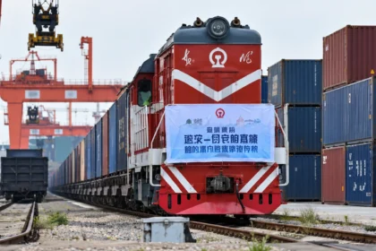 หัวรถจักรสีแดงและขบวนตู้คอนเทนเนอร์ในลานรถไฟขนส่งสินค้า