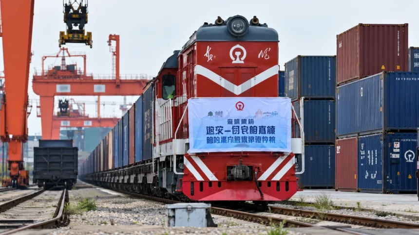 หัวรถจักรสีแดงและขบวนตู้คอนเทนเนอร์ในลานรถไฟขนส่งสินค้า